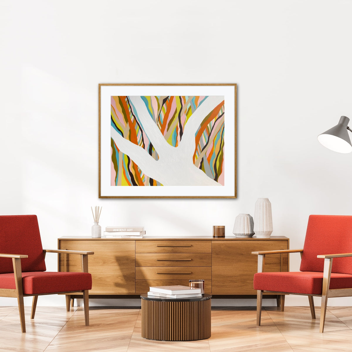 Brilliant Blue Gum framed print displayed in a living room with red accent chairs and warm wood tones