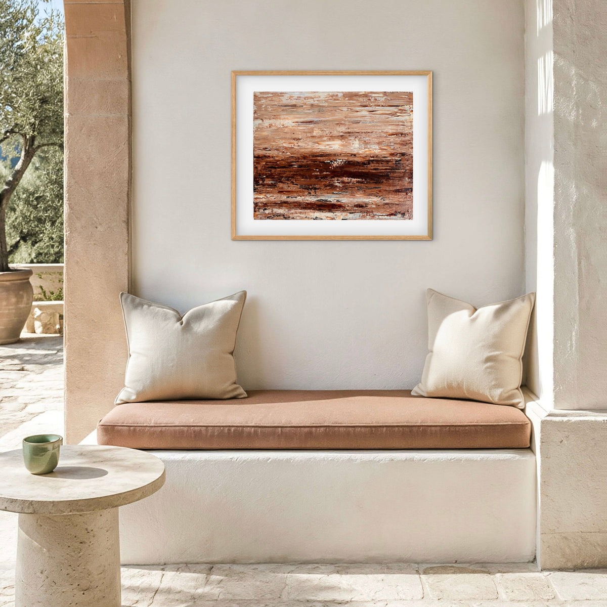 Burnished Earth framed print displayed above an outdoor patio nook with cushions
