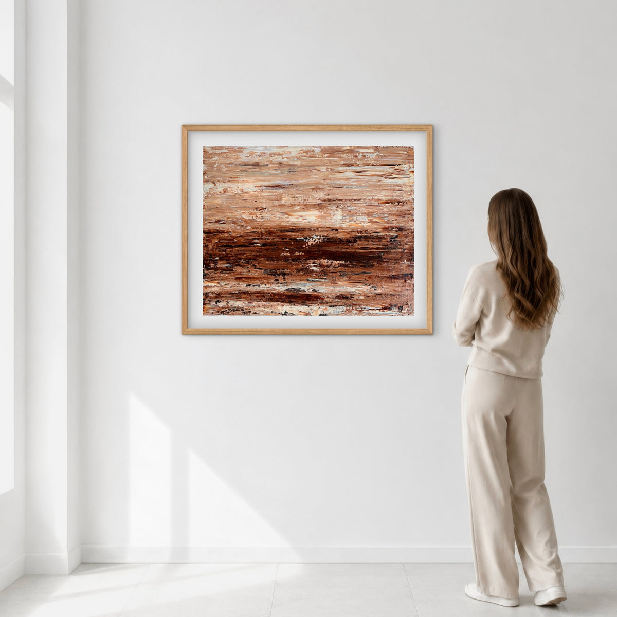 Burnished Earth framed print displayed on a wall as a woman views it, showing scale