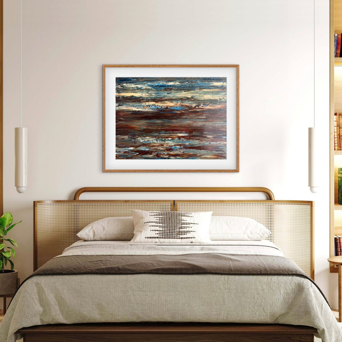 Coastal Drift framed print displayed above a bed with a cane headboard