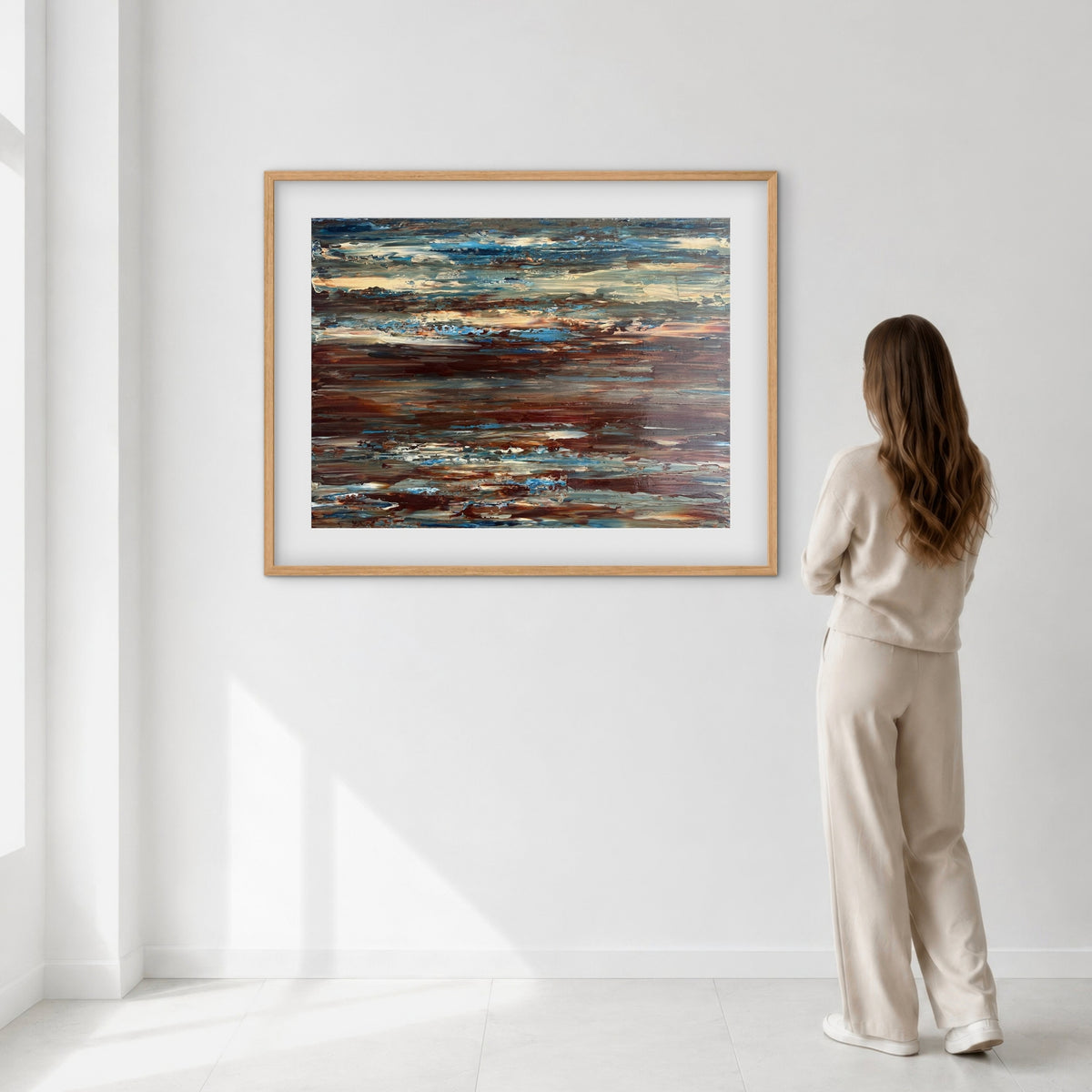 Coastal Drift framed print displayed on a wall as a woman views it, showing scale