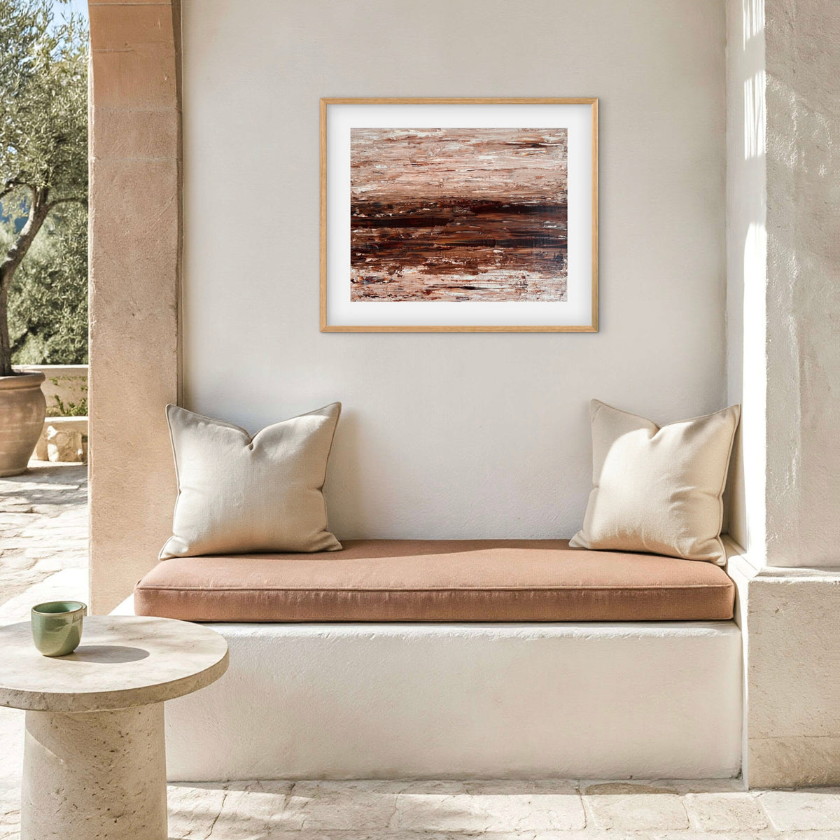 Ocean & Earth I framed print displayed above an outdoor patio nook with cushions