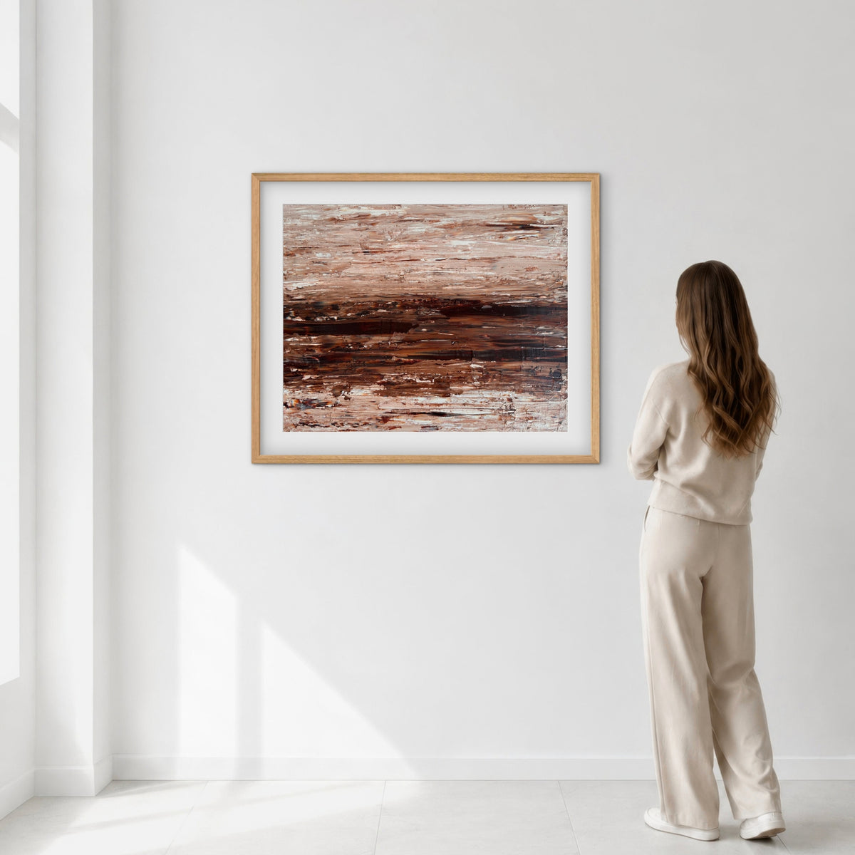 Ocean & Earth I framed print displayed on a wall as a woman views it, showing scale