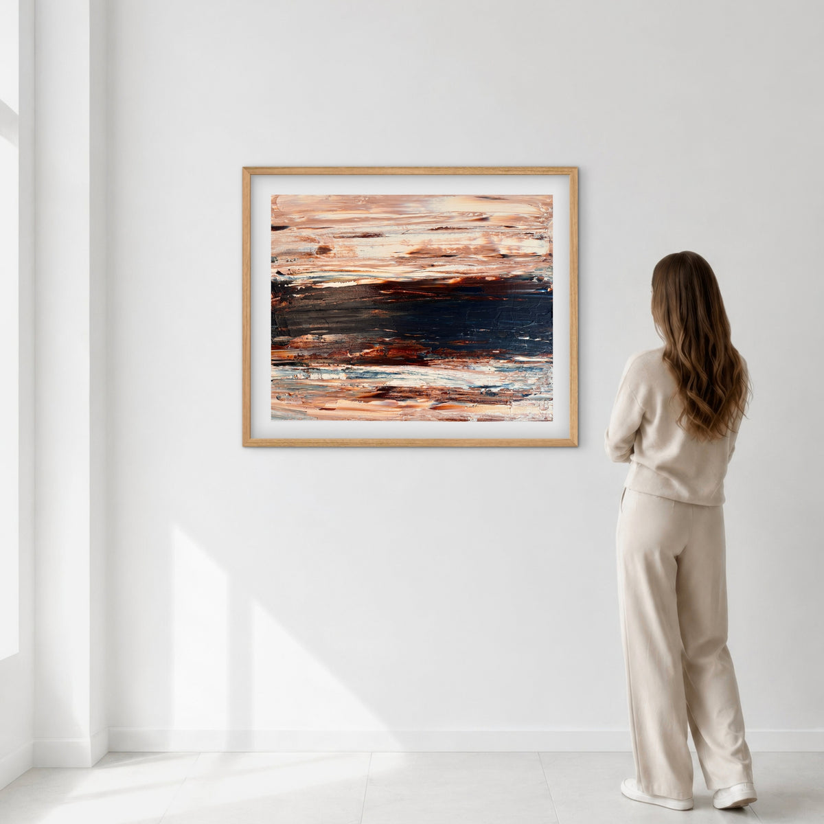 Ocean & Earth II framed print displayed on a wall as a woman views it, showing scale